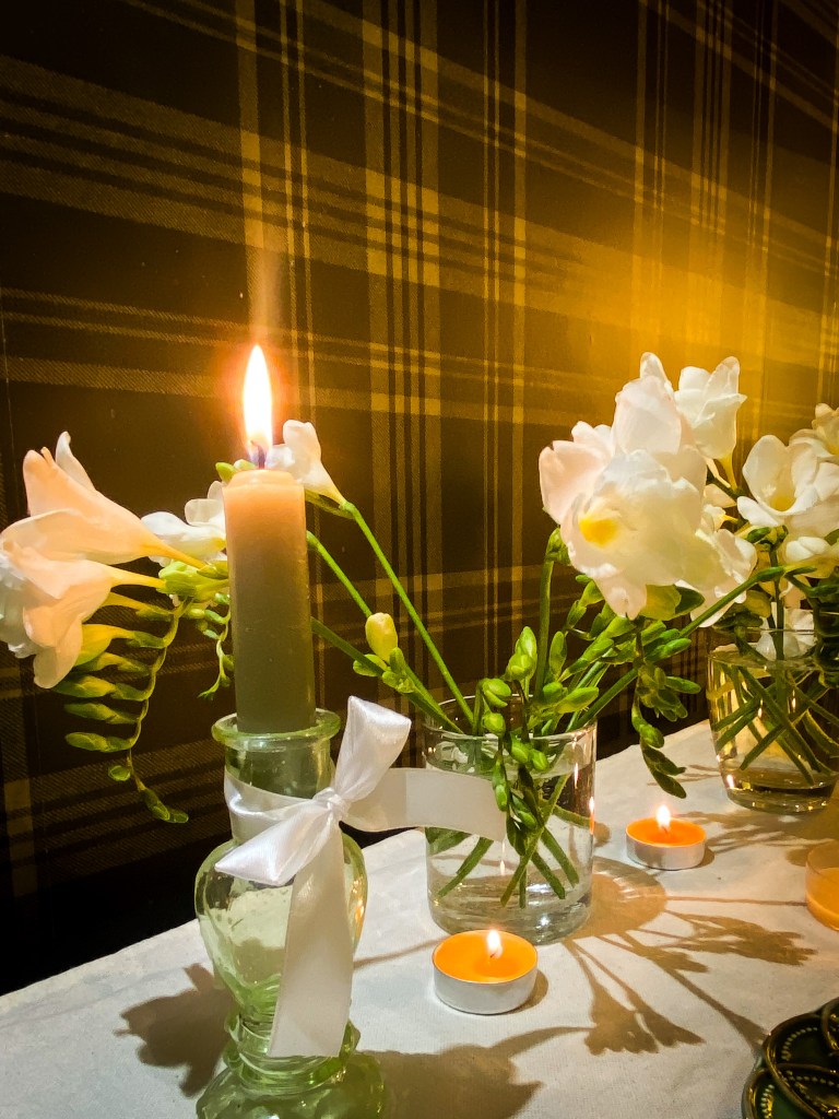A beautiful tables cape and a flickering candle in a romantic dining room.